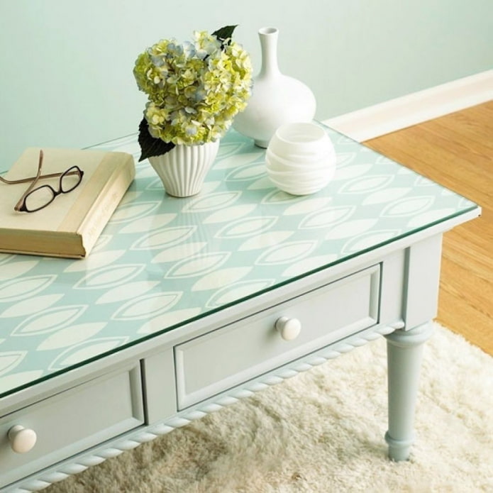 mesa com um pedaço de papel de parede sob o vidro