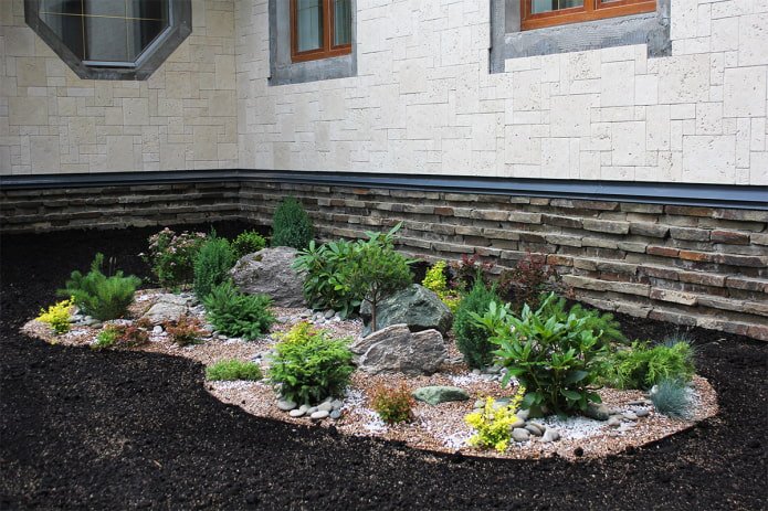 canteiro de flores com pedras perto da casa