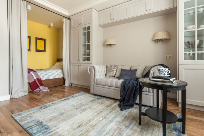 Cama atrás de cortinas e um sofá em arco