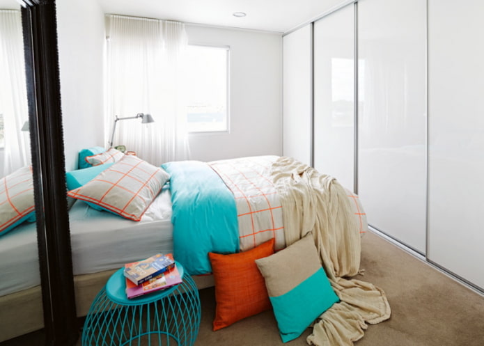 Cama em frente a um guarda-roupa com portas brilhantes