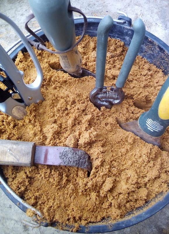 Ferramentas em um balde com areia