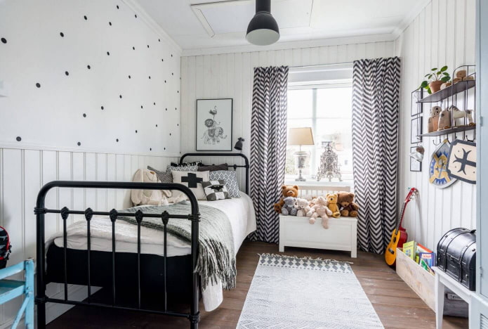 uma cama com cama de ferro forjado em um quarto infantil em estilo escandinavo