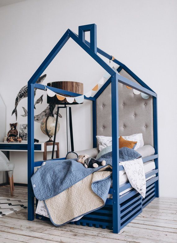 cama azul em formato de casa no quarto do bebê