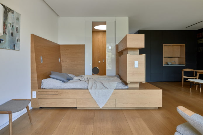 cama em um pódio em um apartamento estúdio