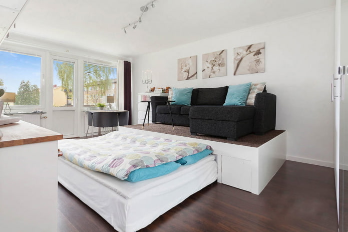 cama em um pódio no interior da sala de estar