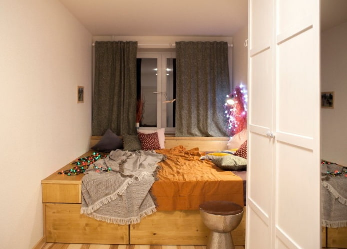cama em um pódio em um quarto pequeno