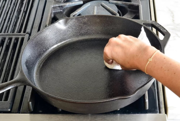 lubrificando uma frigideira de ferro fundido limpa com óleo