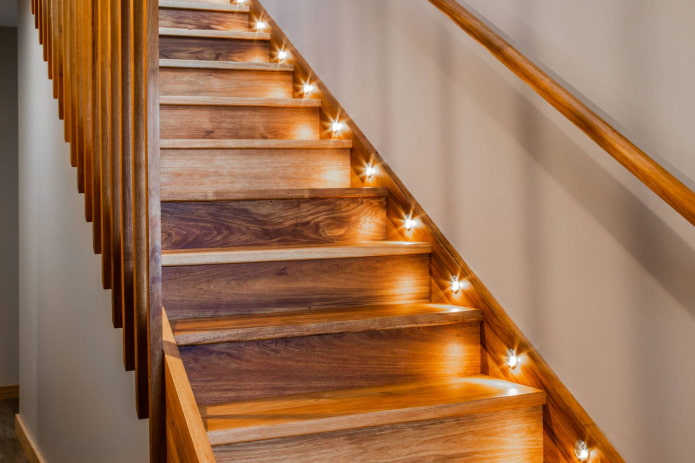 escada de madeira com iluminação de fundo no interior da casa