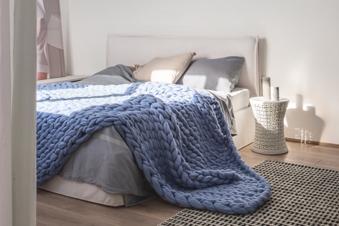cama com uma grande colcha de malha no quarto