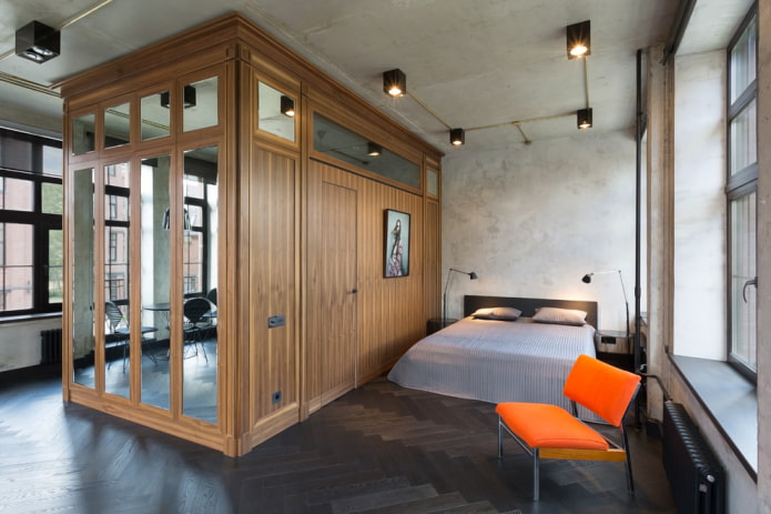um guarda-roupa em forma de divisória em um interior estilo loft