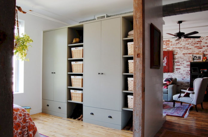 um guarda-roupa em forma de divisória em um interior estilo loft