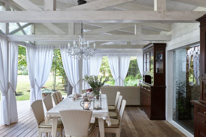 cortinas brancas com ganchos na varanda de uma casa de campo