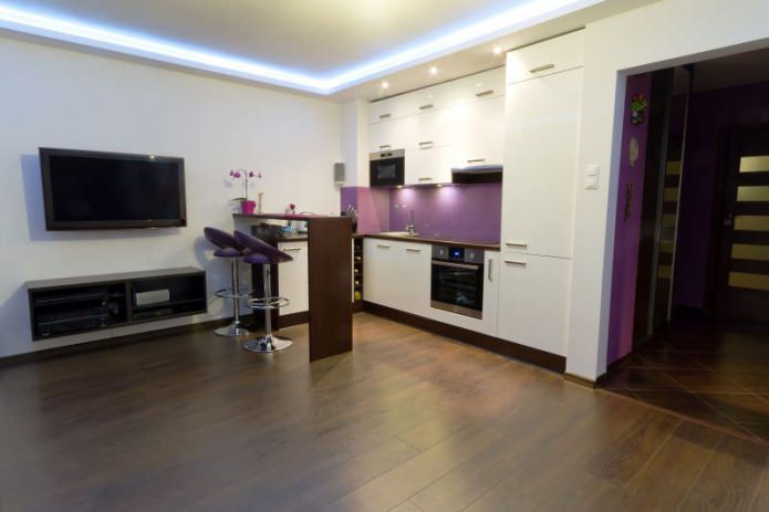 Design de cozinha e sala de estar com balcão de bar em tons de branco e roxo