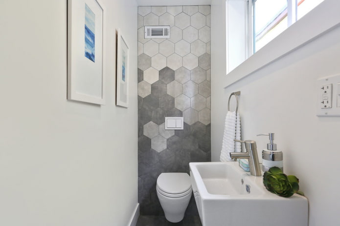 Azulejos em formato de favo de mel atrás do vaso sanitário
