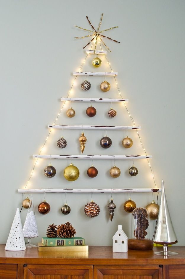 Árvore de Natal feita de gravetos, bolas e guirlanda