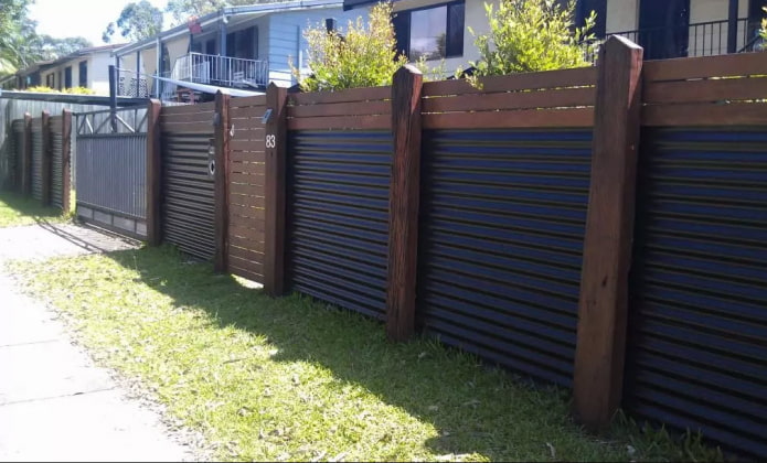 Cerca feita de chapas onduladas com postes de madeira
