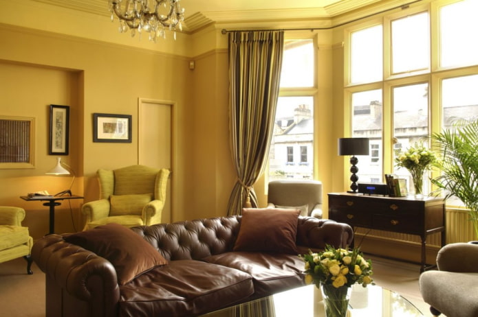 sala de estar amarelo escuro com sofá de couro marrom